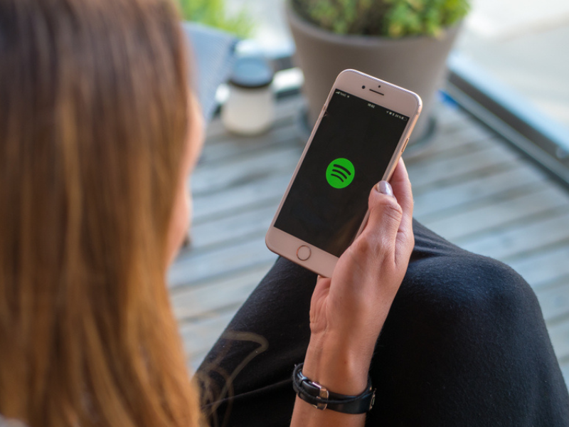 mulher jovem abrindo o aplicativo do spotify