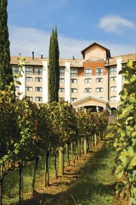 Bento Gonçalves, situada no coração da deslumbrante Serra Gaúcha, no estado do Rio Grande do Sul, é carinhosamente chamada de "A Toscana Brasileira" devido à sua notável semelhança com a região da Toscana, na Itália. A cidade tem suas raízes profundamente ligadas à imigração italiana, com famílias que buscaram melhores condições de vida no Brasil no século XIX. Esses colonizadores italianos trouxeram consigo não apenas a língua e a cultura, mas também a paixão pelo vinho e a tradição de cultivar uvas, transformando Bento Gonçalves em uma verdadeira meca para os amantes da enologia. Os visitantes podem explorar as inúmeras vinícolas da região, degustar vinhos de alta qualidade e aprender sobre o processo de produção, tudo isso enquanto apreciam as belas paisagens que lembram de forma impressionante a Toscana italiana.Além de seu renomado cenário vitivinícola, Bento Gonçalves oferece uma experiência completa para os sentidos. Os restaurantes locais servem autêntica gastronomia italiana, com pratos tradicionais como massas frescas e risotos preparados com ingredientes frescos da região. Além disso, a cidade abriga a charmosa rota turística conhecida como o "Caminho de Pedra", onde os visitantes podem explorar construções históricas e saborear produtos artesanais. Bento Gonçalves é um verdadeiro pedaço da Itália em terras brasileiras, com sua beleza cênica, vinhos excepcionais e hospitalidade calorosa, oferecendo uma experiência que transporta os visitantes diretamente para a encantadora Toscana, sem sair do Brasil.